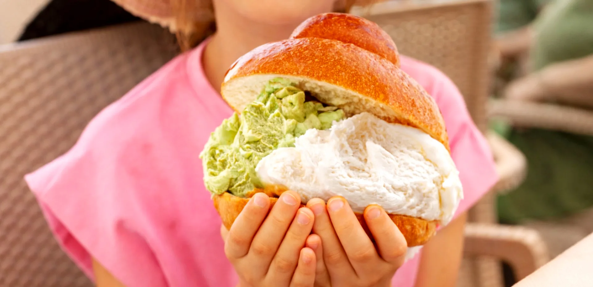 Bambina che tiene una brioscia col tuppo farcita di gelato